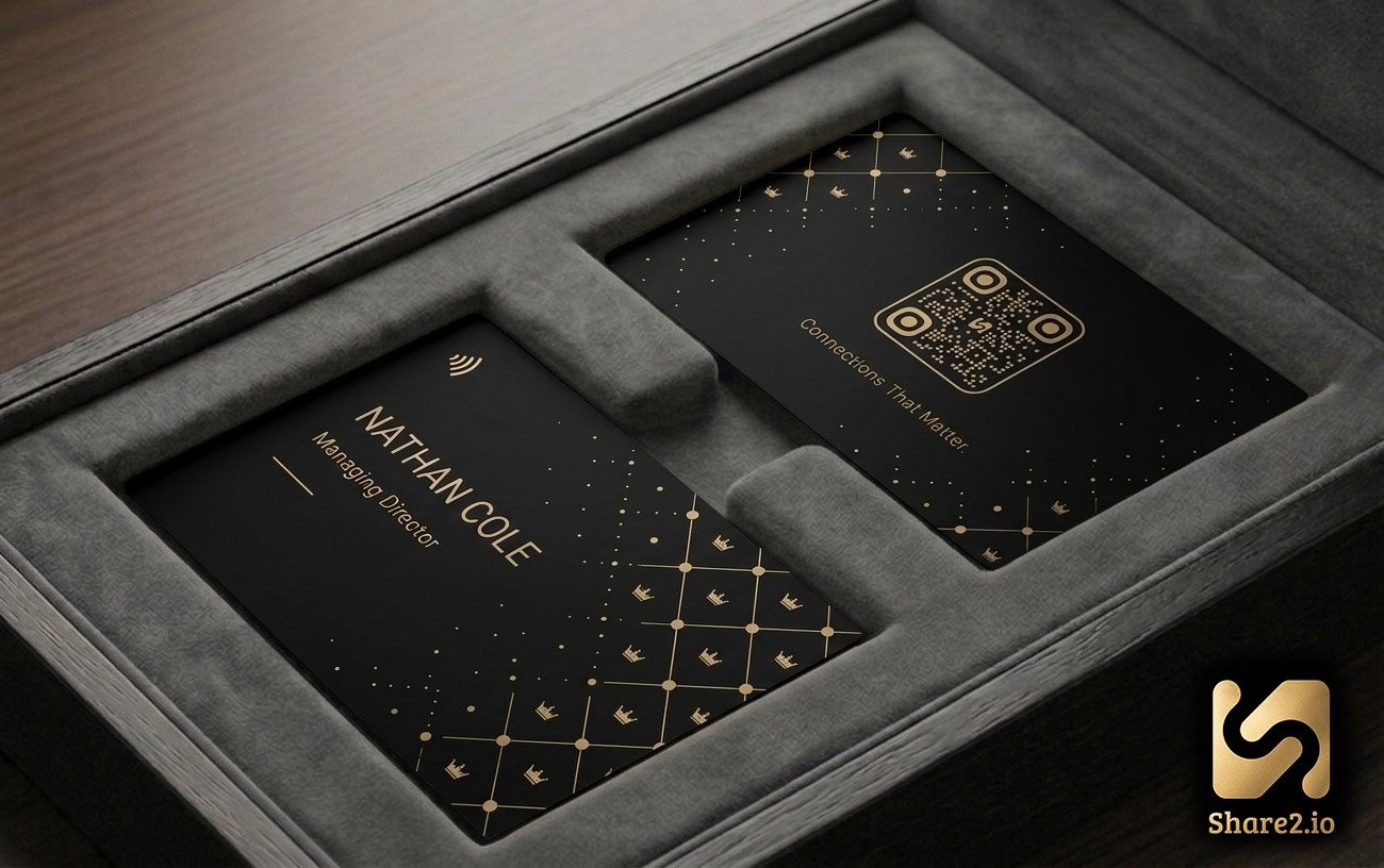 Regalia design — matte black NFC business card with a gilded crown lattice pattern and gold QR code, presented in a grey suede gift box